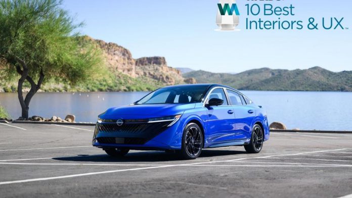 Blue 2026 Nissan Sentra sedan parked by a scenic lakeside with mountains and desert landscape in the background under clear…
