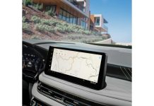 2027 Infiniti QX60 Adds SPORT Trim, Starts at $51,890 as Brand Chases Volume Growth 2027 Infiniti QX60 dashboard display showing navigation map, with desert landscape and modern architecture visible through w…