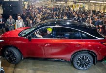 2027 INFINITI QX65 Enters Production at Tennessee Plant, Starts at $53,990 Red 2027 INFINITI QX65 SUV displayed at factory launch event surrounded by crowd of spectators and employees in industrial m…