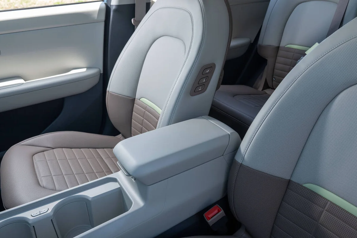 2027 Kia Seltos interior showing dual-tone front seats with gray leather and quilted accents, center armrest, and back seati…