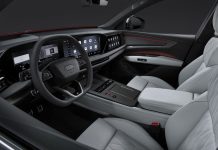 Audi Q9 Interior Revealed: Automatic Doors, 4D Sound, and Seven Seats Audi Q9 interior featuring dual digital displays, leather steering wheel, light gray seats with red accent trim, and panoram…