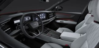 Audi Q9 Interior Revealed: Automatic Doors, 4D Sound, and Seven Seats Audi Q9 interior featuring dual digital displays, leather steering wheel, light gray seats with red accent trim, and panoram…