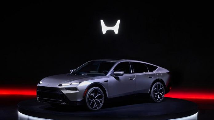 Silver Honda hybrid SUV displayed on illuminated stage with glowing H logo above and red ambient lighting highlighting the v…